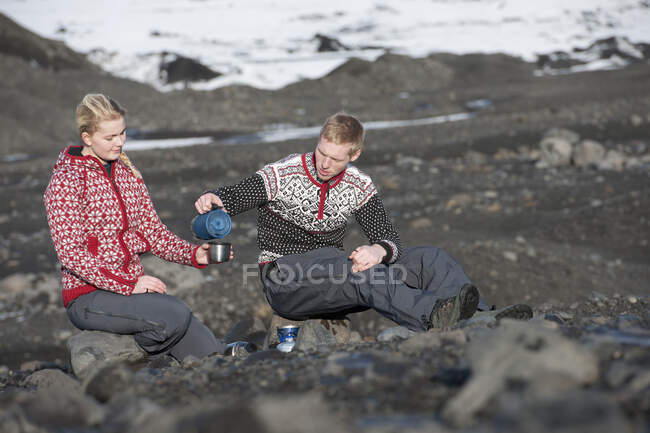 Junges Paar bei einem Picknick in karger Landschaft in Island — Stockfoto
