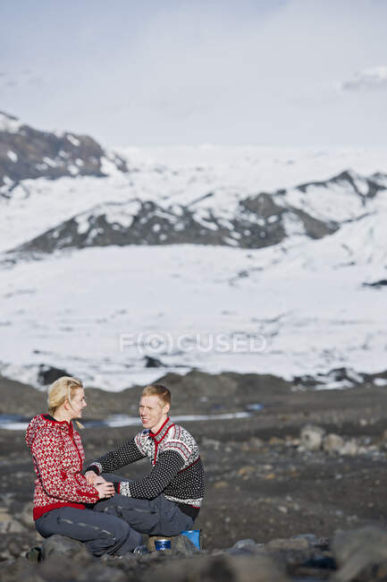 Pareja joven haciendo un picnic en un paisaje estéril en Islandia - foto de stock