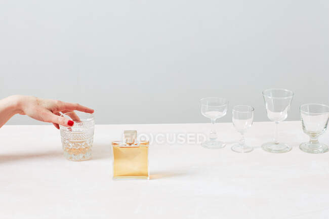Femme tenant un verre sur un fond blanc — Photo de stock