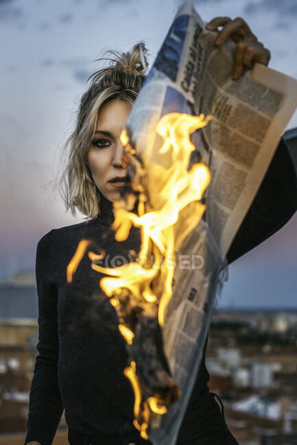 Femme blonde brûlant un journal. — Photo de stock