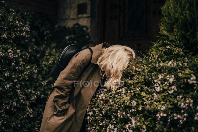 Блондинка модель в плащі, лежить на дереві . — стокове фото