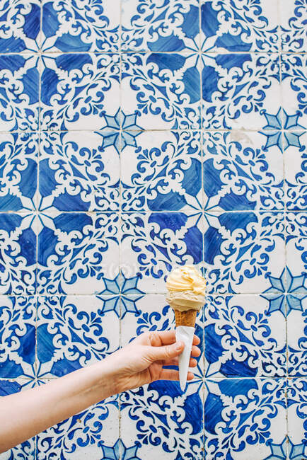Ice cream cone in hand on background — Stock Photo