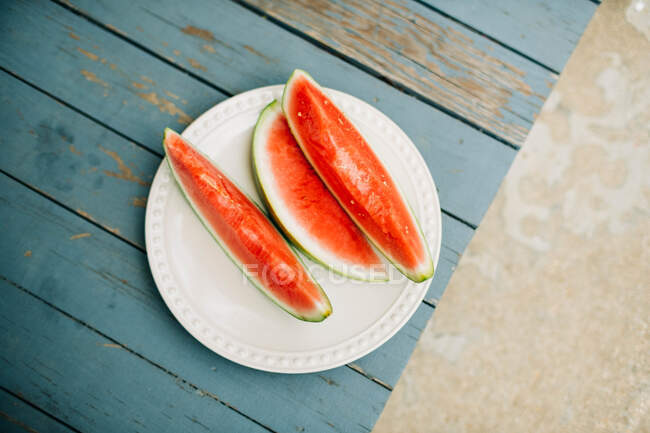 Fresh watermelon on a plate on a wooden background — Stock Photo