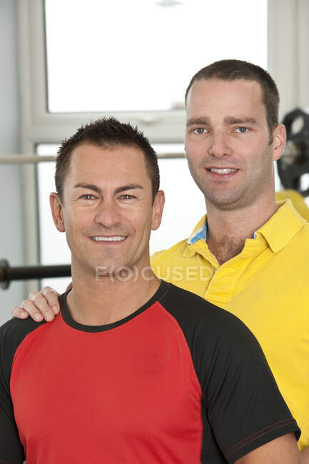 Gay couple looking at camera in gym in the UK — Stock Photo