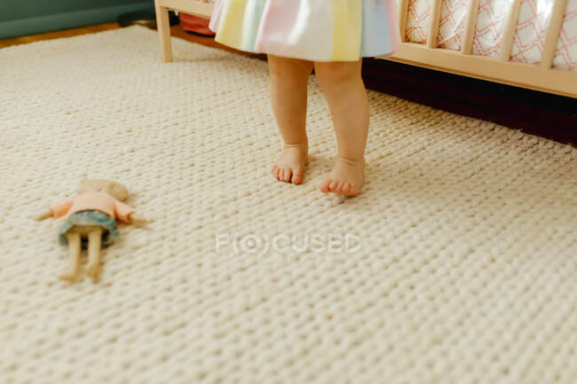 Little girl standing on carpet at home — Stock Photo