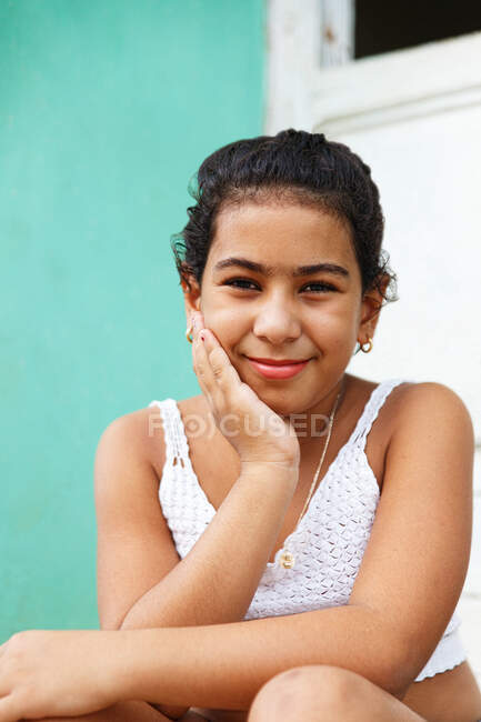 Chica cubana sentada en la puerta de su casa, Trinidad-Cuba - foto de stock