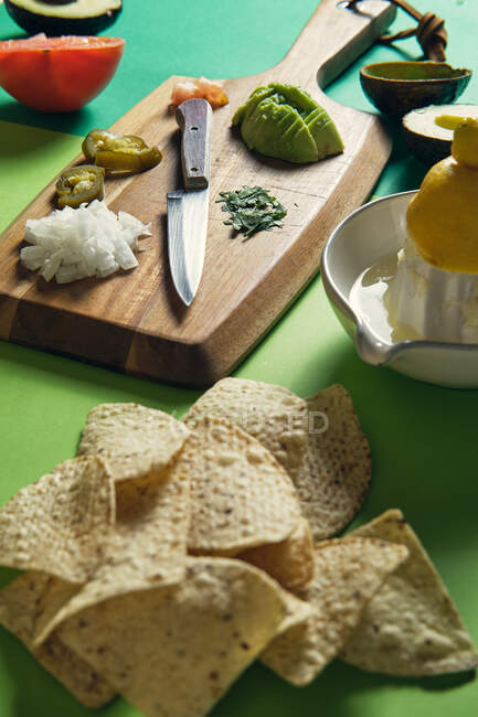 Guacamole con chips de tortilla sobre fondo. - foto de stock