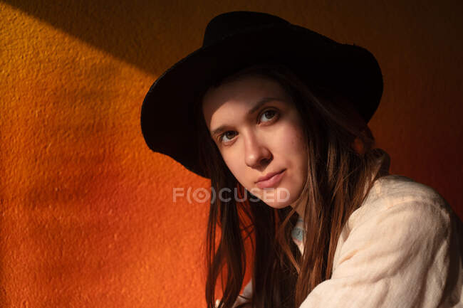 Retrato de mujer joven en sombrero sentarse solo en la cafetería - foto de stock