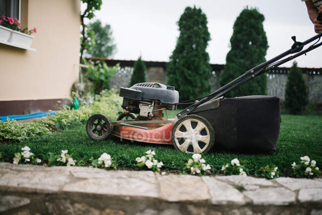 Nahaufnahme eines Rasenmähers in einem Garten im Hintergrund, Nahaufnahme — Stockfoto
