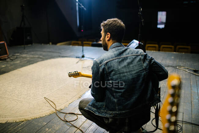 Back view of young guitarist on stage. Soundcheck concept. — Stock Photo