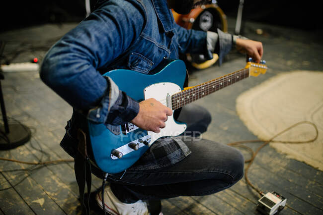 Man playing guitar on stage on background, close up — Stock Photo