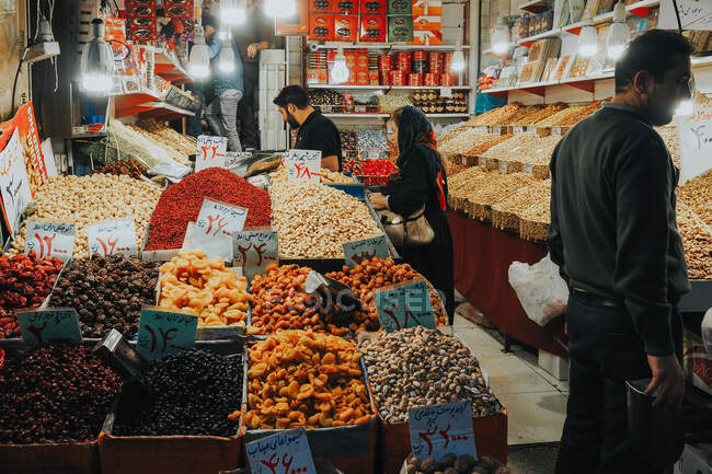 Especias y frutos secos en las escalas y platos en un viejo bazar en Teherán - foto de stock