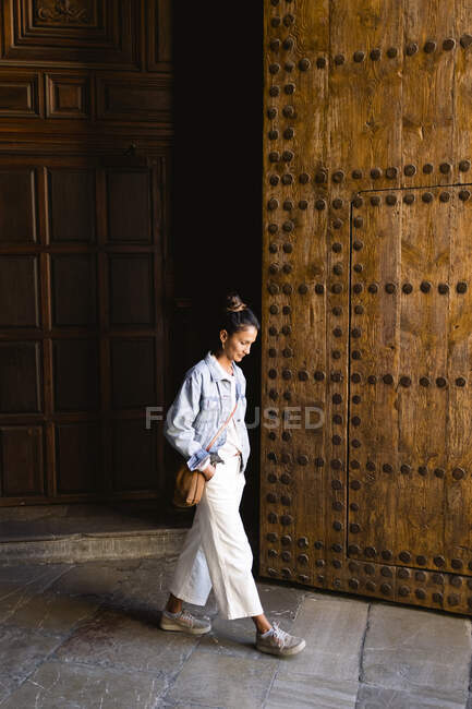 Молода жінка виходить з церкви в історичному кварталі Гранади. — стокове фото