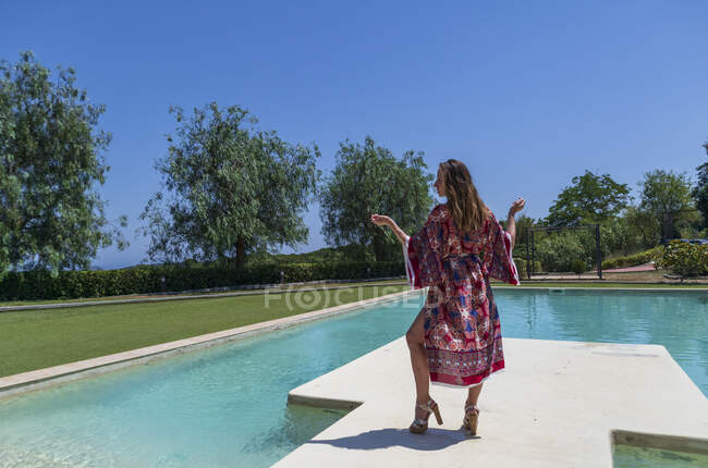 Menina loira posando no verão com um vestido à beira da piscina — Fotografia de Stock