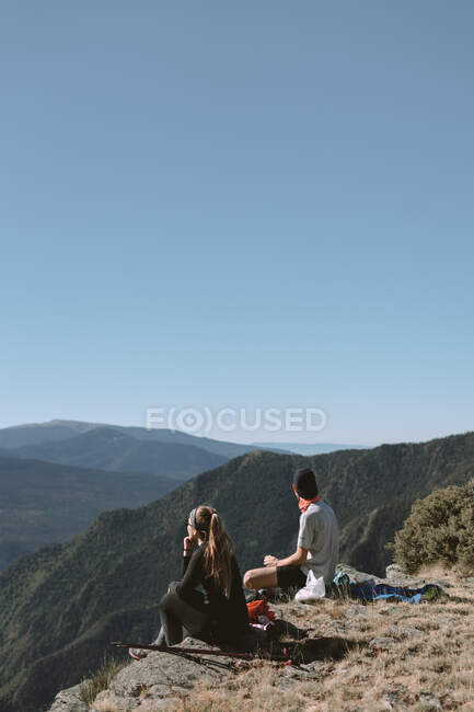 Mädchen und Junge in den Bergen beobachten die Landschaft während sie sich ausruhen — Stockfoto
