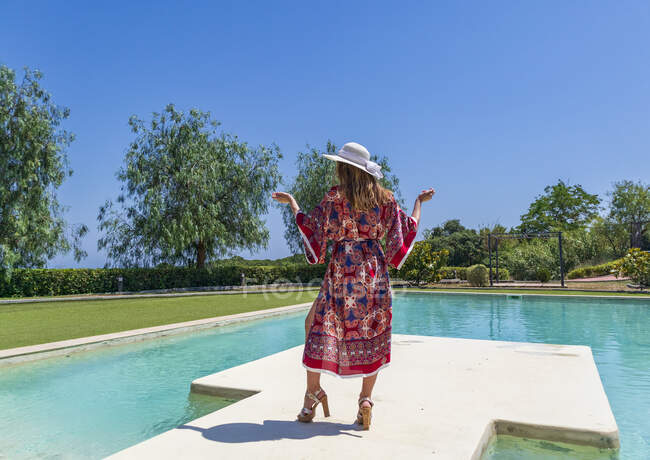 Ragazza bionda in posa in estate con un vestito a bordo piscina — Foto stock