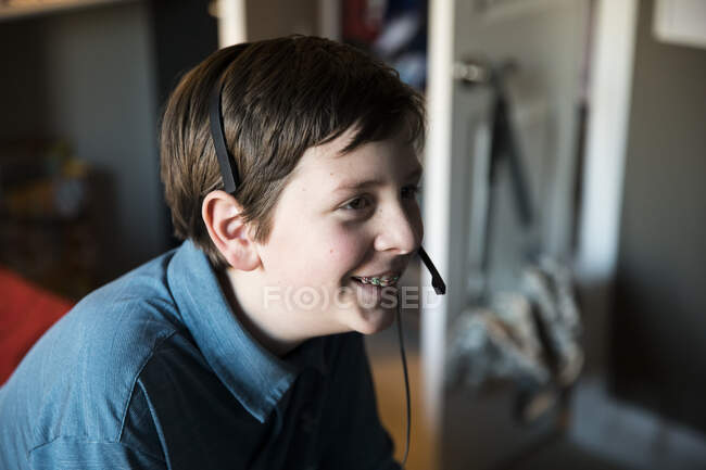 Vista lateral de adolescentes sorridentes com aparelhos que usam fone de ouvido para jogos — Fotografia de Stock