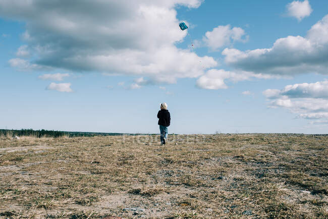 Kleiner Junge lässt an einem schönen sonnigen Tag einen Drachen auf einem Hügel steigen — Stockfoto