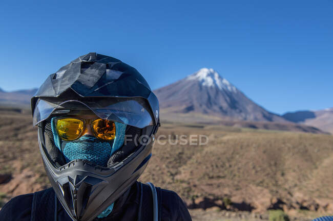 Woman with motorbike helmet, in front of the stratovolcano Licancabur — Stock Photo