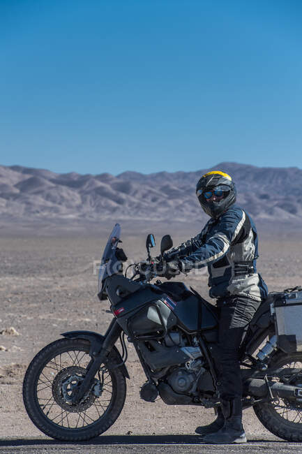 Человек на мотоцикле в пустыне Атакама — стоковое фото