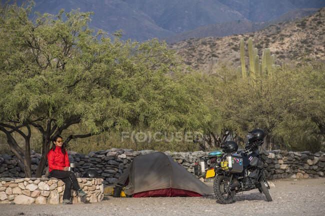 Woman sitting beside motorbike camp at the Ruinas de Quilmes — Stock Photo