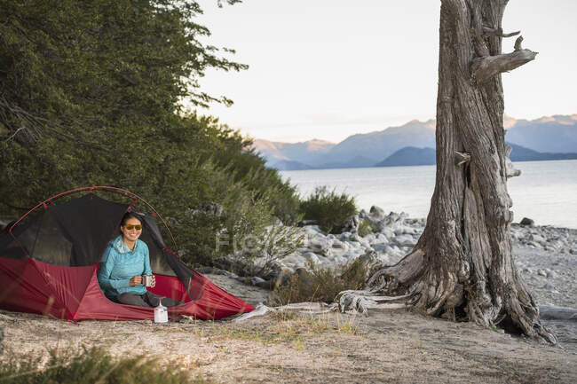 Mujer descansando en el campamento en el lago Nahuel Huapi en Patagonia - foto de stock