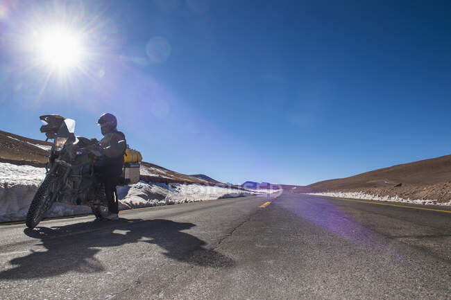 Woman standing next to her touring motorbike close to Paso de Jama — Stock Photo