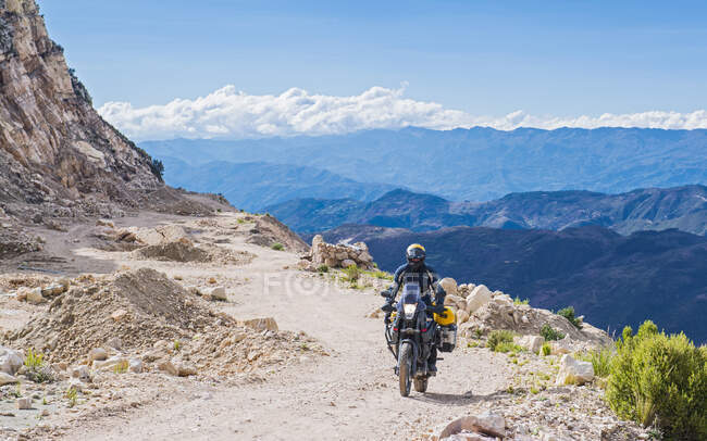 Чоловік їде на мотоциклі на дорогах з гравію в Болівії. — стокове фото