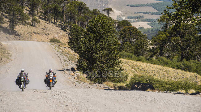 Couple on touring motorbikes driving on gravel road in Argentina — Stock Photo