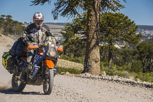 Homme en motos de tourisme conduisant sur route de gravier en Argentine — Photo de stock