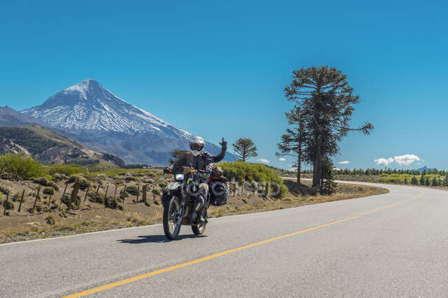 Una donna in moto da turismo. Vulcano Lanin sul retro, Argentina — Foto stock
