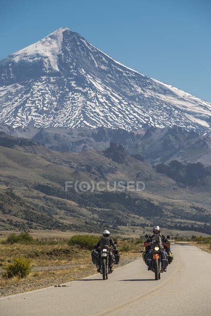 Couple on touring motorbikes. Lanin volcano in the back, Argentina — Stock Photo