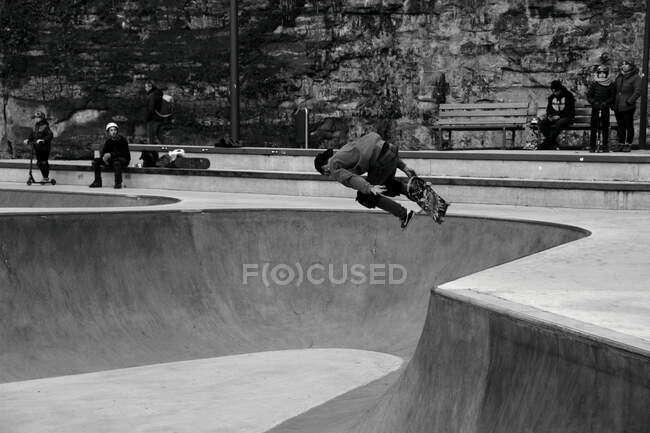 Skater salta no parque de skate com a adrenalina fluindo em movimento — Fotografia de Stock