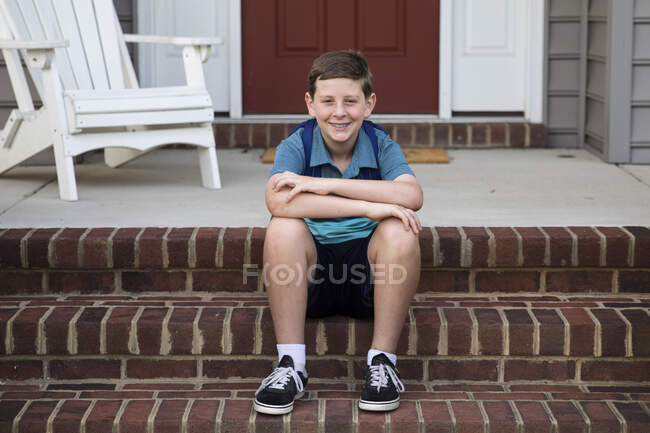 Happy Tween Boy Senta-se na frente de tijolo Passos — Fotografia de Stock