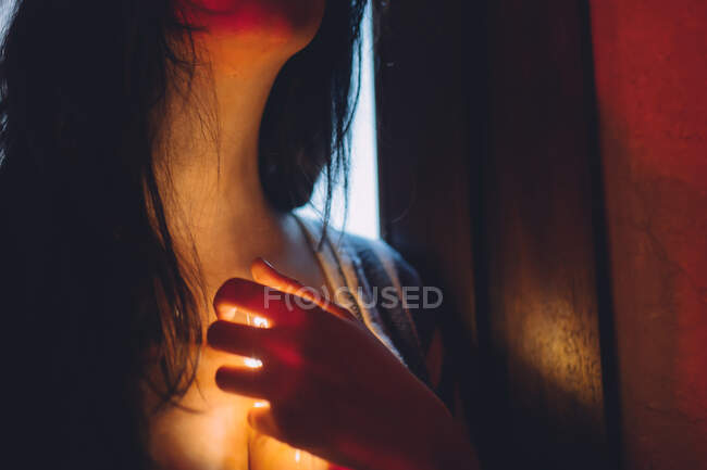 Mujer con una luz que brilla por su garganta - foto de stock