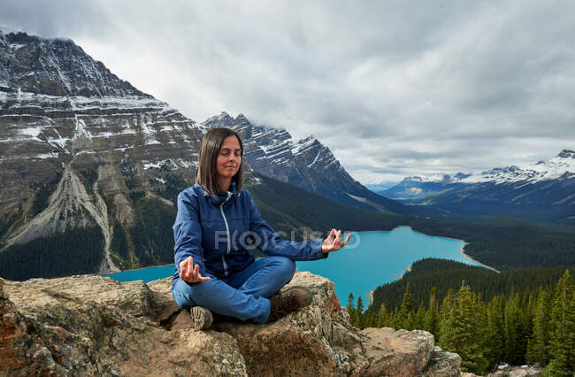 Mujer relajada haciendo yoga en el lago Peyto, Parque Nacional Banff - foto de stock