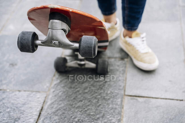 Young woman on skateboard in town, close up on the skate board — Stock Photo