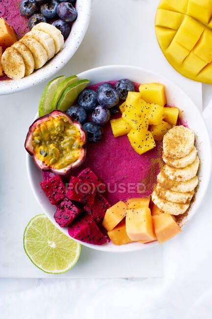Top view fruit bowls for healthy breakfast. Pitaya smoothie bowls with mango and summer fruits — Stock Photo