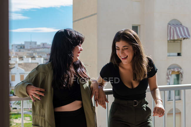 Two young women are having fun on a balcony of her house — Stock Photo