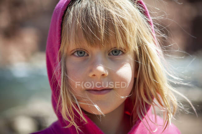 Fille regarde dans la caméra avec des cheveux blonds au Colorado River Arizona — Photo de stock