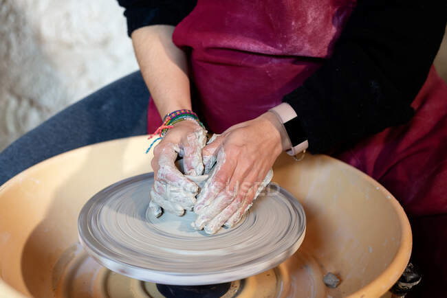 Художница-керамистка работает в своем ателье с гончарным колесом — стоковое фото