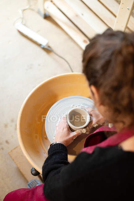 Artista de cerâmica feminina trabalhando em seu atelier com a roda de cerâmica — Fotografia de Stock