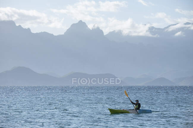 Одна жінка веслувала на вершечку каяка недалеко від острова Кармен у Лорето (штат Баха, Каліфорнія, Мексика).. — стокове фото