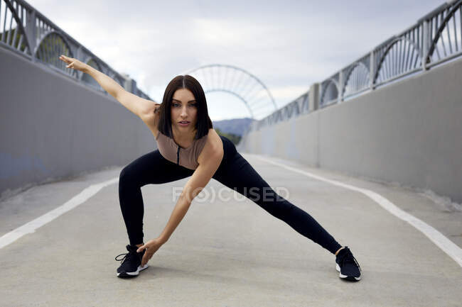 Retrato de mulher exercendo na ponte contra o céu — Fotografia de Stock
