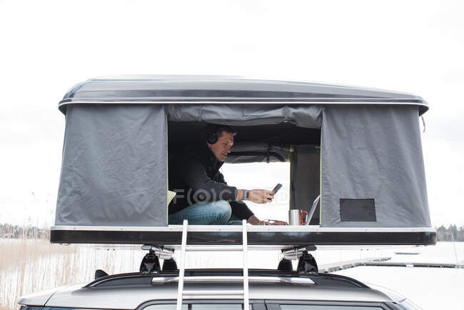 Homme travaillant à partir d'une tente tout en distance sociale du bureau — Photo de stock