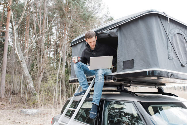 Man working from a home office in a tent whilst social distancing — Stock Photo
