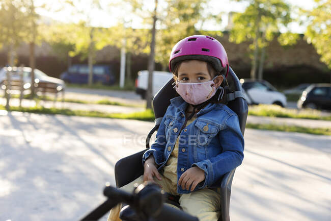 Маленькая девочка в маске готова к велосипедной прогулке — стоковое фото