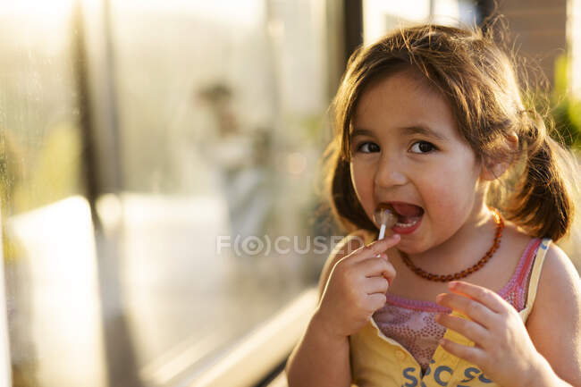 Petite fille manger une sucette — Photo de stock