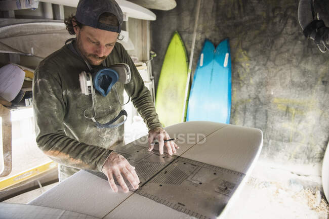 Young man making surfing board. — Stock Photo