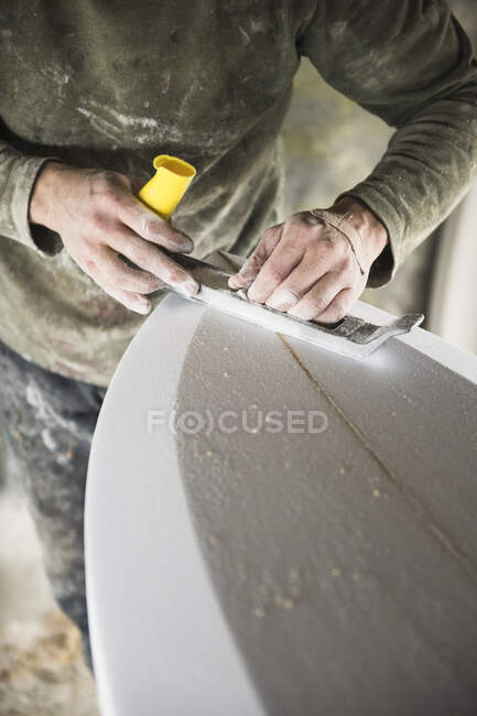 Hombre haciendo tabla de surf en el taller. Rhode Island, Nueva Inglaterra - foto de stock